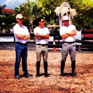 three jumping trainers in the warmup ring